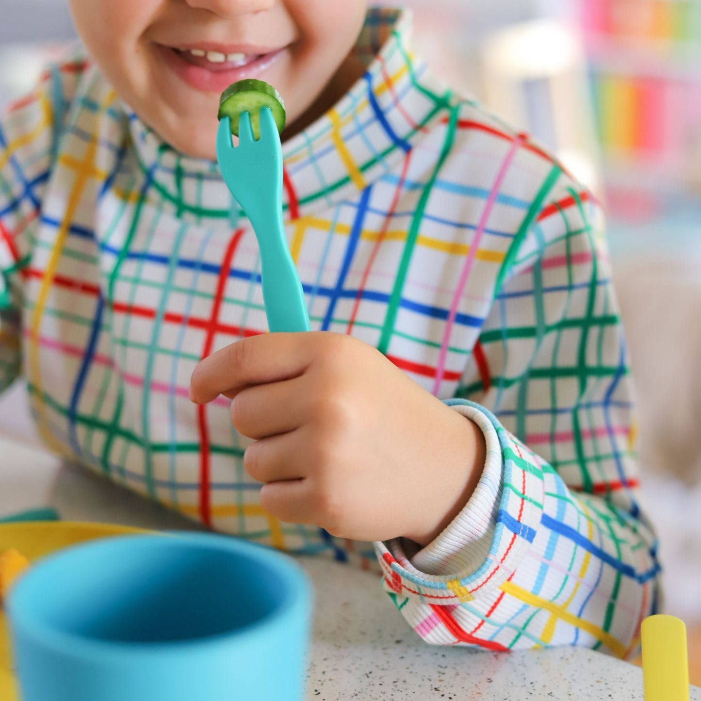 a girl using a bobo&boo plant-based bamboo fork while eating cucumber