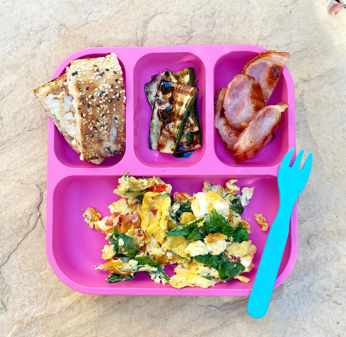 bobo&boo pink divided plate with has bacon & egg breakfast in it