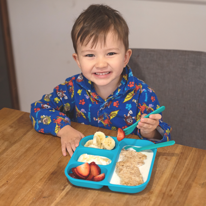 a little boy eating his breakfast weetbix happily on out bobo&boo dinnerware 